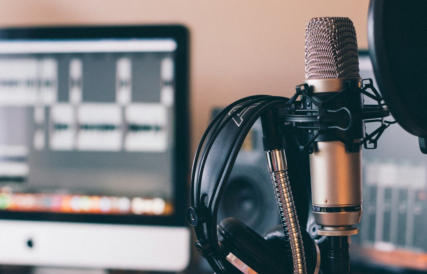 Studiomikrofon, Kopfhörer und Audiosoftware während einer Podcastproduktion